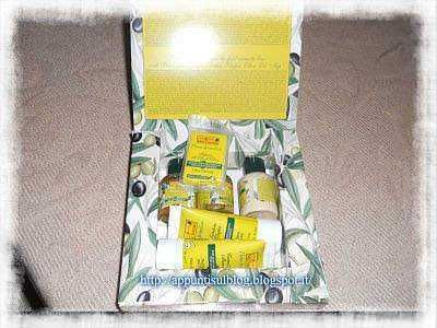 Elegante logo con sfondo giallo, con fiori di campo stilizzati e testo "Idea Toscana, Cosmetici per il benessere" dedicato a prodotti cosmetici naturali toscani.