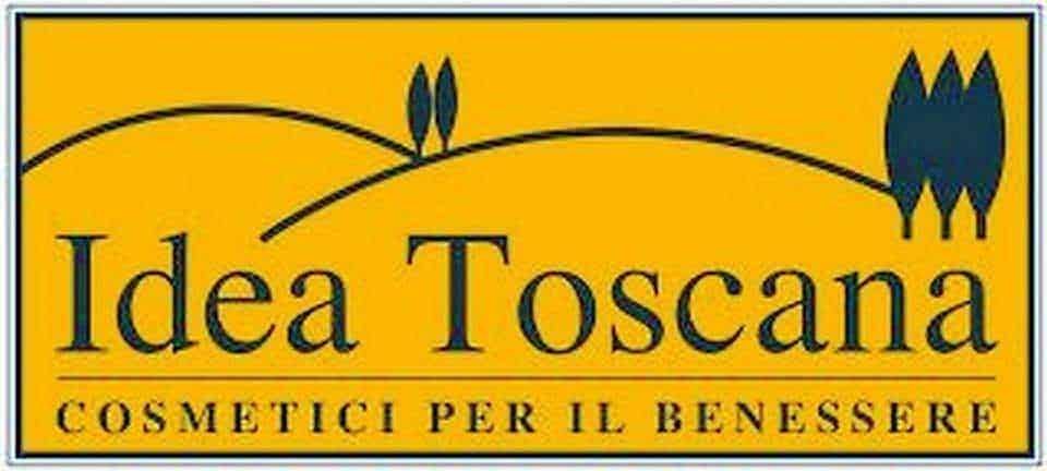 Elegante logo con sfondo giallo, con fiori di campo stilizzati e testo "Idea Toscana, Cosmetici per il benessere" dedicato a prodotti cosmetici naturali toscani.