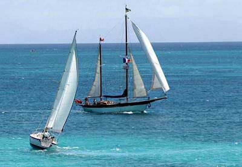 Vela a mare con barca a vela tradizionale e moderna che naviga sul mare blu, immagine di navigazione, avventura e relax in mare aperto.