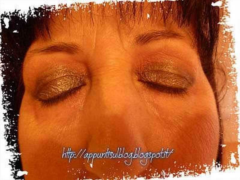 Viso di una donna con trucco oro sugli occhi, chiusi, stile artistico e creativo, foto di sensibilità e bellezza, ideale per blog e articoli di moda moda e stile di vita.