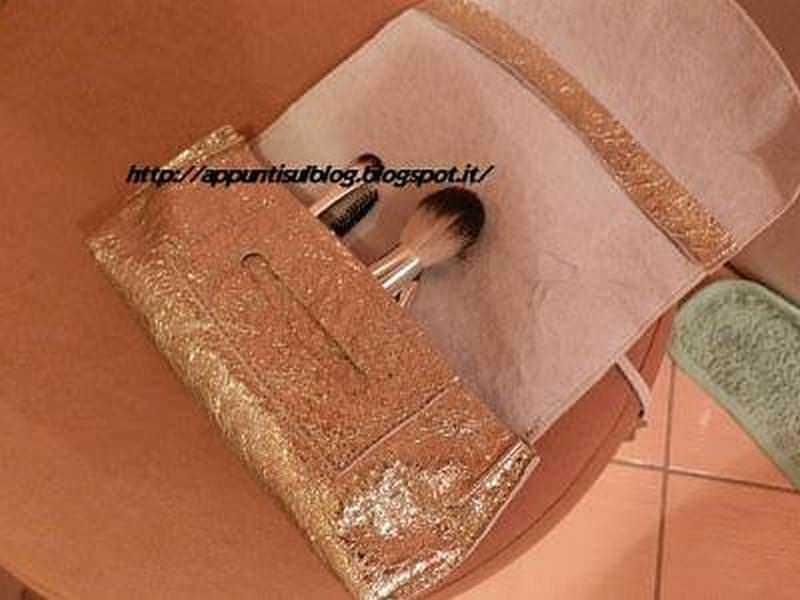 Cofanetto porta attrezzi per trucchi con spugnette e pennelli per make-up in fantasia dorata e rosata, ideale per l'organizzazione della cosmetica a casa o in viaggio.