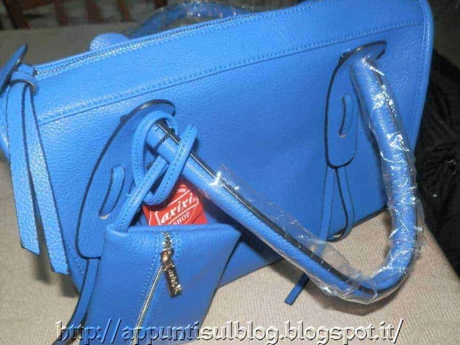 Elegante borsa blu in pelle con dettagli metallici, ideale per uso quotidiano e occasioni speciali. Design raffinato con manico e tasca frontale, perfetta per completare il tuo look di moda.