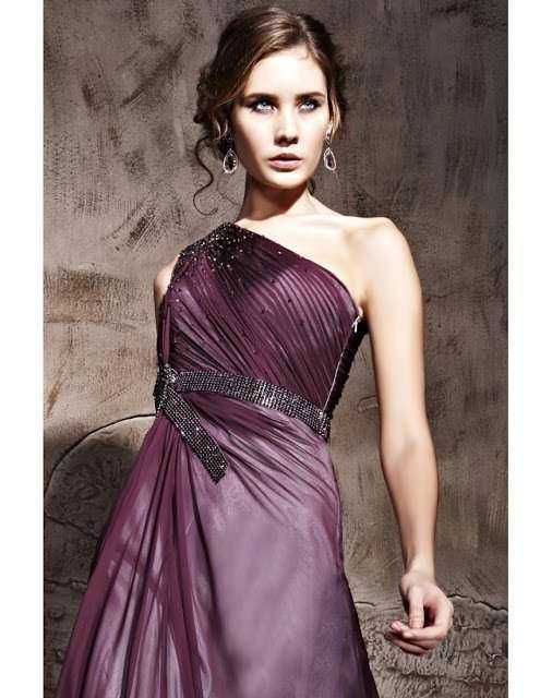 Elegante donna in abito da sera viola con dettagli di strass e plissettature, perfetto per occasioni speciali e eventi formali.