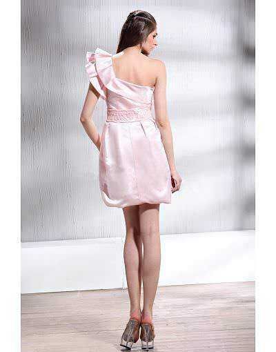 Vestito rosa elegante con dettagli a pizzo e gonna corta, indossato da una modella in un ambiente sobrio. Ideale per eventi speciali e occasioni formali, abbigliamento femminile alla moda.