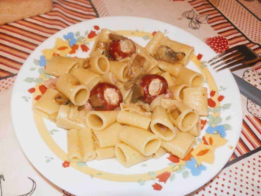 Pasta rigatoni con salsiccia e funghi, piatto di cucina italiana, spaghetti ripieni di carne, food experience, ricetta tradizionale, appetitoso e gustoso.
