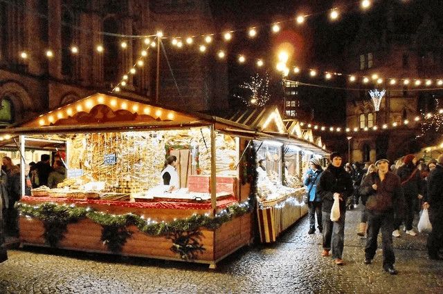 La sera di Natale a Cava dei Tirreni, un borgo medievale, in provincia di Salerno 4 Suggestive Christmas market stall illuminato con luci e decorazioni festive, atmosfera natalizia vivace con visitatori che passeggiano tra le bancarelle in un contesto urbano serale.