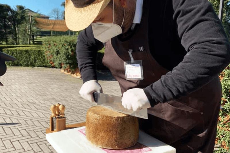 Frittata di maccheroni e Gran Mugello 2 Frittata di maccheroni con gran mugello: Frittata di maccheroni e Gran Mugello. Fiocco di neve di formaggio stagionato tagliato con coltello da un esperto casaro al sole, mentre indossa protezioni, in un ambiente rurale.