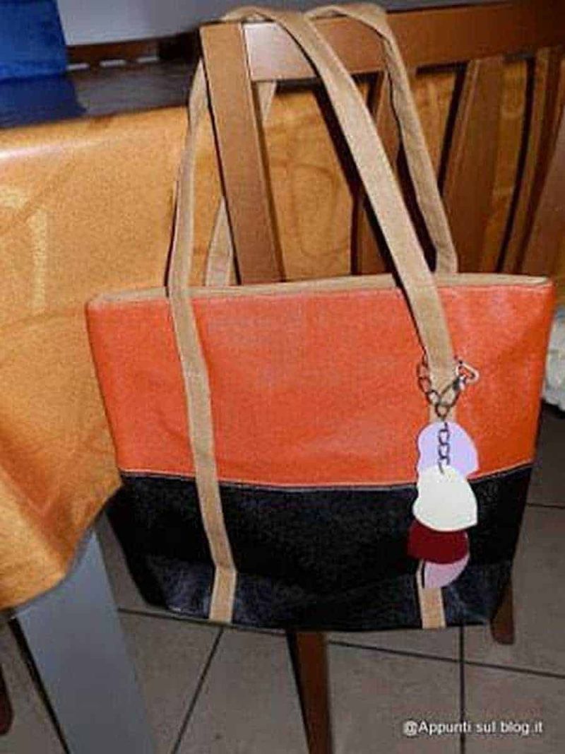 Dressinn borse multi funzioni 6 Borsa tote in tessuto colorato con dettagli beige e accessori moda, appoggiata su una sedia di legno. Perfetta come accessorio moda casual e versatile. Ideale per outfit estivi e quotidiani.