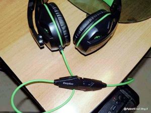 EasyAcc cuffie gaming headset tecnologiche 5 Auricolari gaming con microfono e cavo verde, headset over-ear nere e verdi per gaming e streaming, collocati su un tavolo di legno nero, accessori elettronici gaming.