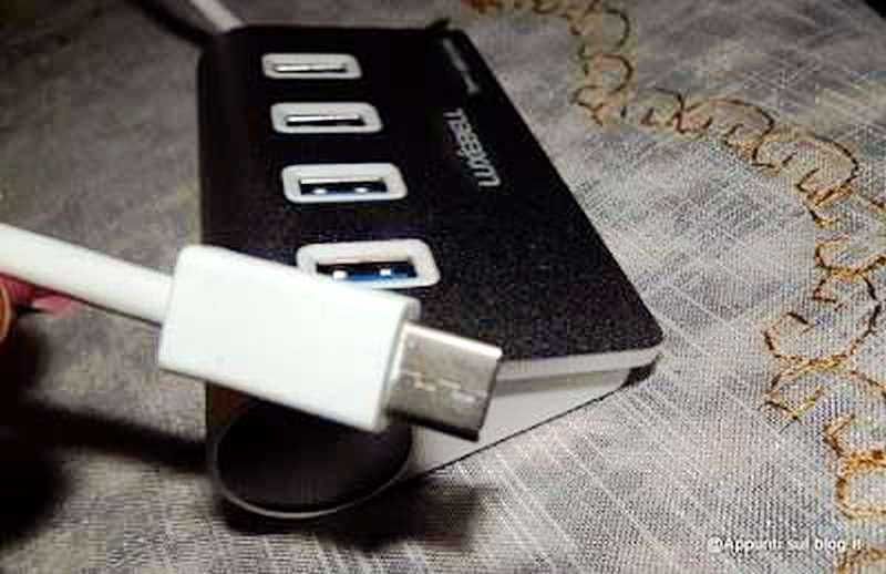 Chiavetta USB collegata a un power bank portatile, pronta per ricaricare dispositivi elettronici ovunque.