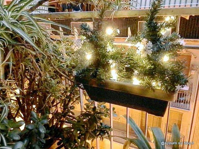 Fioriera natalizia con luci led: Guardrail decorazione natalizia con luci e rami di pino in un appartamento, atmosfera calda e festosa, decorazione di Natale elegante e moderna, ambientazione domestica.