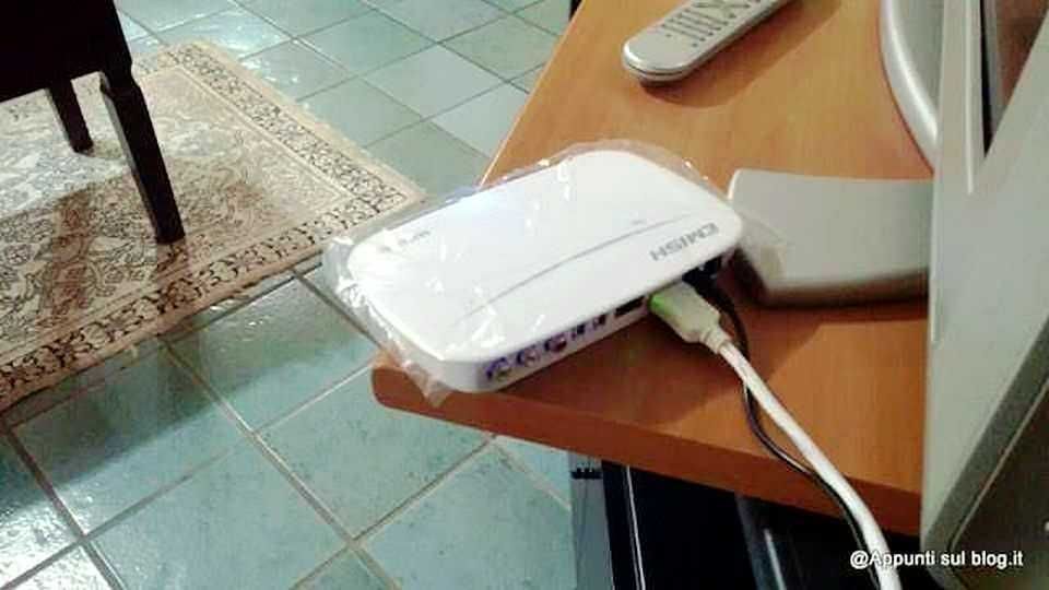 Modem/router Wi-Fi collegato a computer su scrivania, dispositivi tecnologici per connessione internet, tecnologia domestica, connessione di rete, gadget elettronici.
