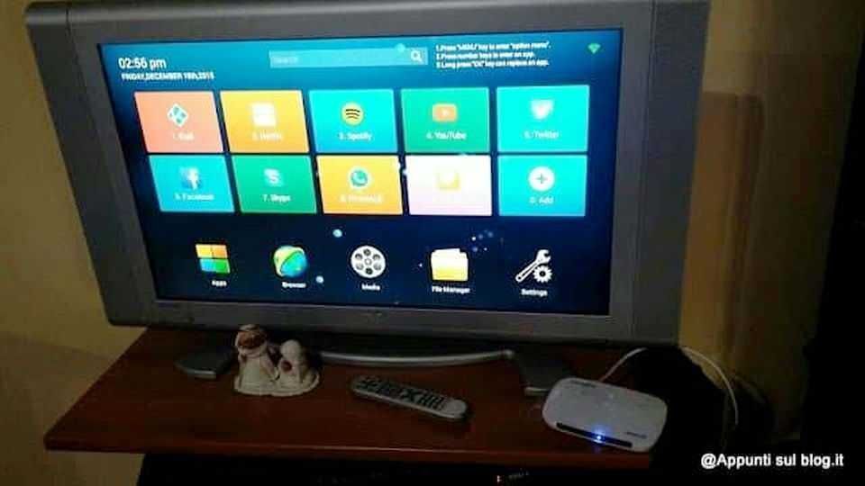 TV con interfaccia smart TV, controllo remoto e dispositivi collegati, come lettore multimediale, su un mobile in ambiente domestico.