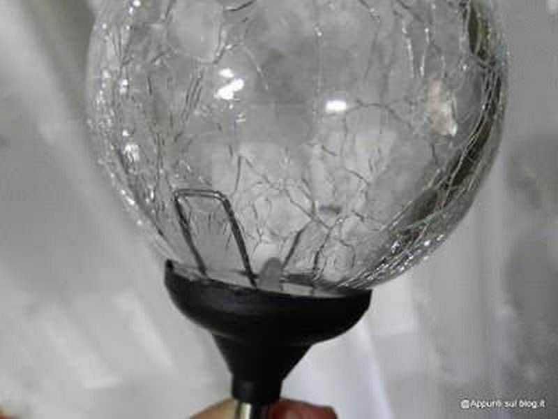 Esky Sky of Electronics, sfere per illuminare il buio 4 Bulbina di vetro rotto con schegge e superficie fragile, dettaglio di oggetto di cristalleria danneggiato, focus sulla rottura e materiali trasparenti.