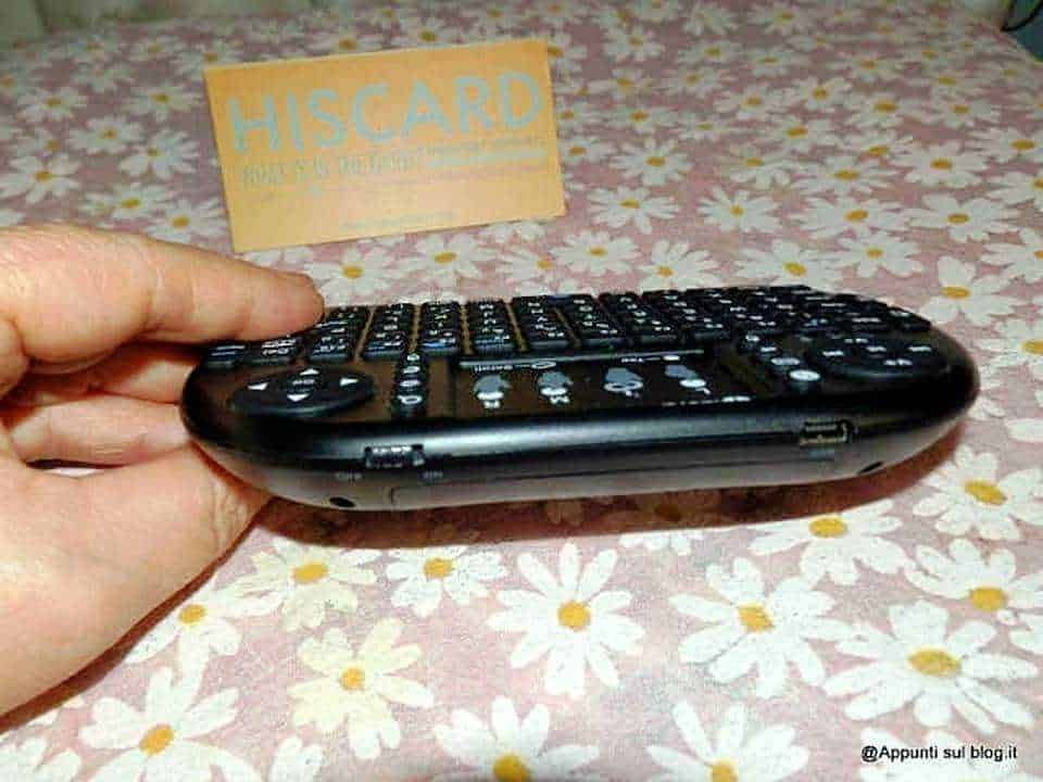 Telefono portatile con tastiera fisica, immagine di un dispositivo smart, ideali per tecnologia e gadget, utilizzato come rivoluzione digitale, inserito su tavolo con sfondo floreale.