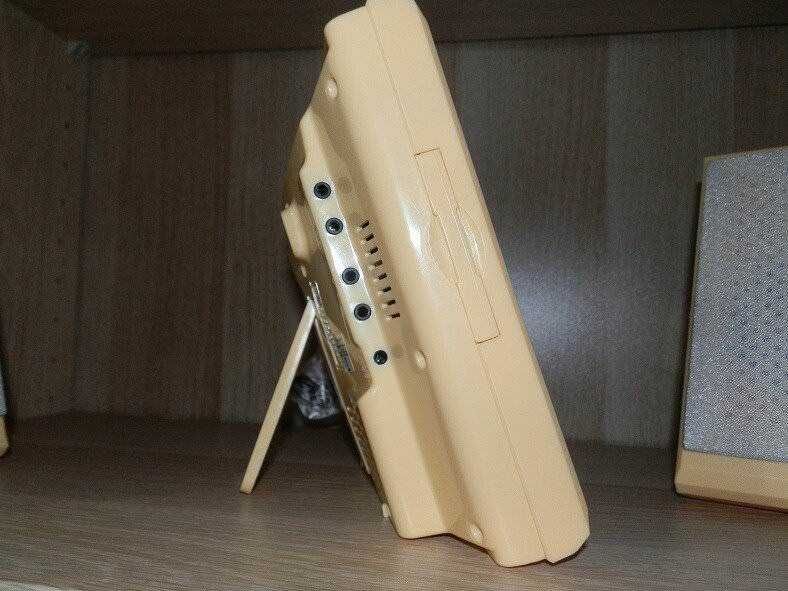 Portatile vintage in plastica beige con manico integrato, vista laterale su scrivania in ufficio o studio.