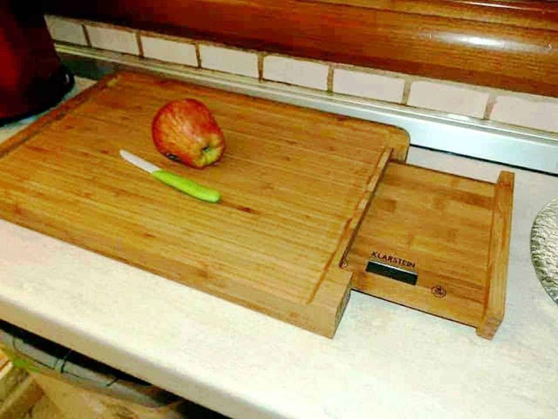 Klarstein mixer, prodotti indispensabili in cucina per pasti veloci 10 Fetta di mela e coltello su tagliere di legno, oggetto di cucina per affettare frutta.