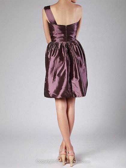 Elegante abito da cocktail in tessuto satinato viola con gonna svasata e spalline sottili, perfetto per occasioni speciali e serate eleganti.