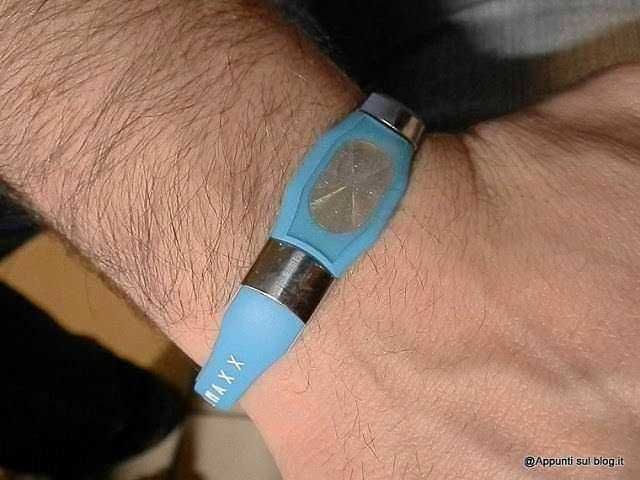 Braccialetto fitness blu sul polso con display digitale, monitoraggio attività e salute, ideale per sport e benessere quotidiano.