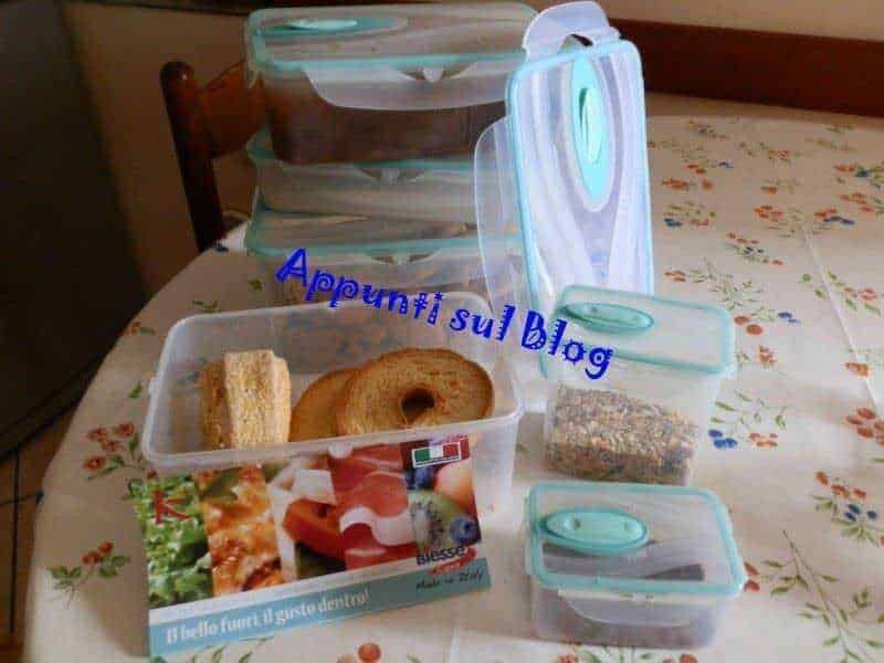 Contenitori plastica Biesse per conservare, surgelare e cucinare 3 Finestra di contenitori per alimenti con snack e dolci, organizzati su una tovaglia floreale, ideale per la cura e la conservazione del cibo quotidiano, perfetto per appunti e suggerimenti di cucina.