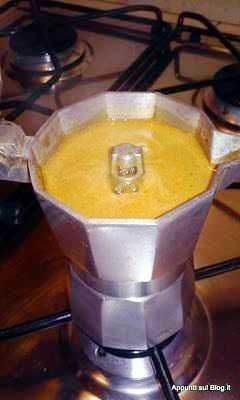 Moka moderna in acciaio inox su piano cottura a gas, pronta per preparare caffè aromatico.