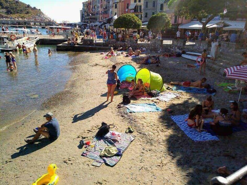 Spiaggia affollata con gente che prende il sole e si rilassa