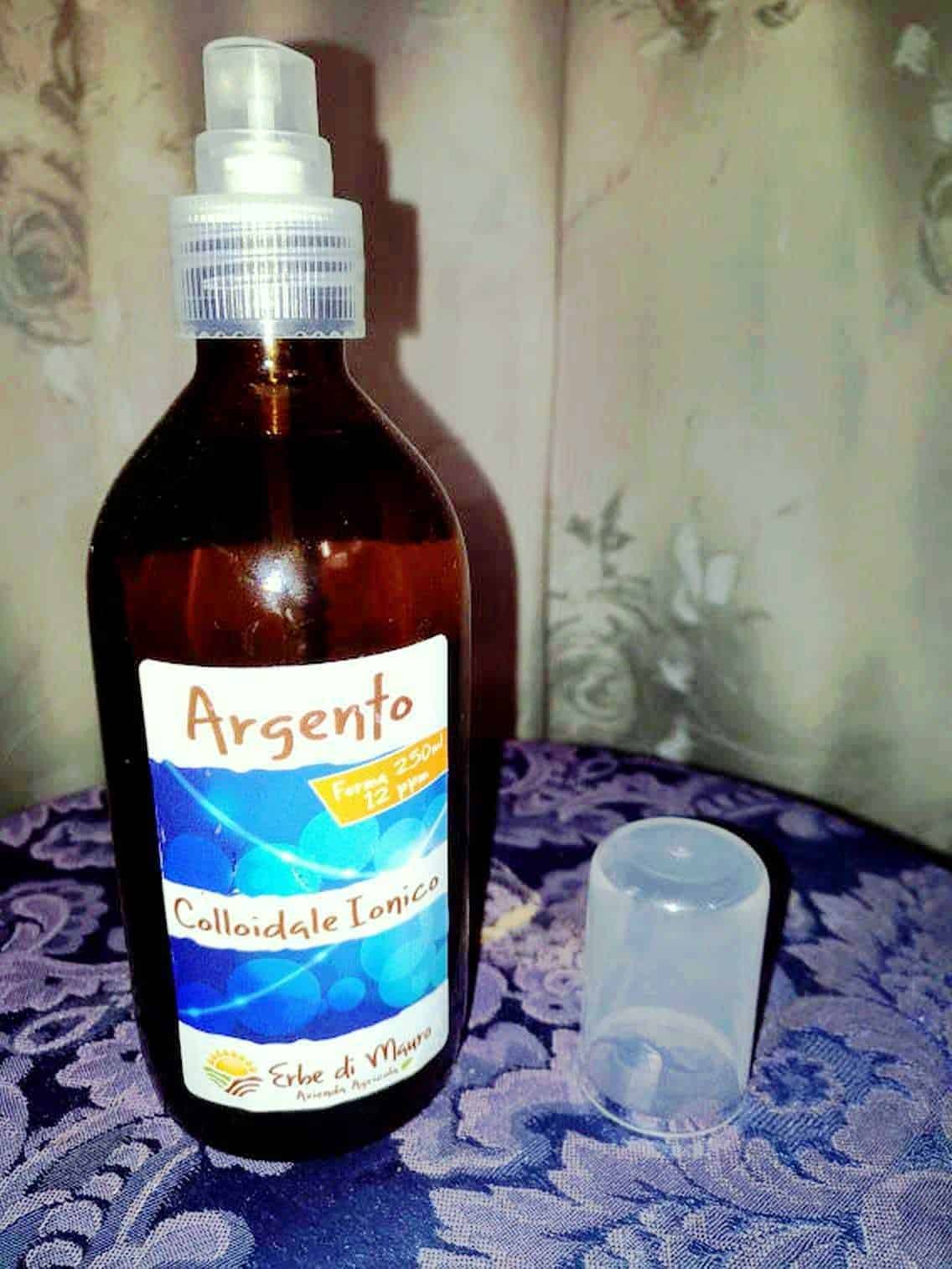 Argento colloidale in bottiglia di vetro marrone con spray, usato come trattamento naturale per il benessere e l'igiene personale.
