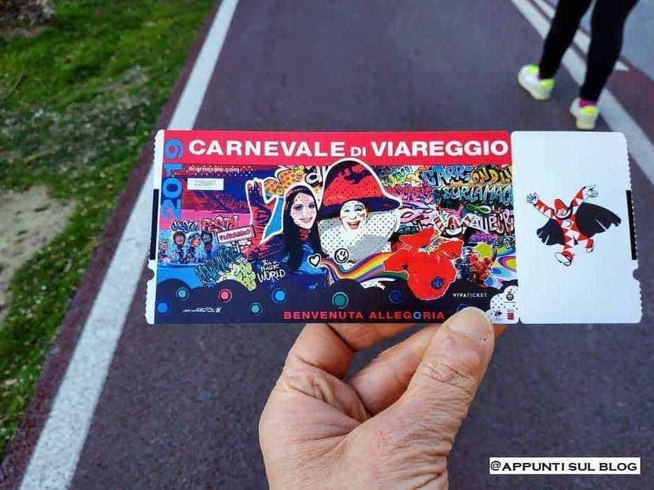 Carnevale di viareggio 2019: Maschera nera con dettagli scintillanti e piume, donna con capelli ricci rossi sorridente, decorazioni festose, stile carnevale o party, sfondo con disegni di fiori blu.