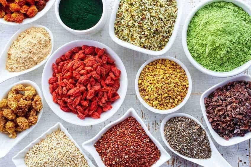 Semi di quinoa variopinti in ciotole, spezie e ingredienti naturali per ricette salutari. Perfetti per insalate, smoothie e piatti vegani. Ricerca di ingredienti naturali e integrali per un'alimentazione sana.