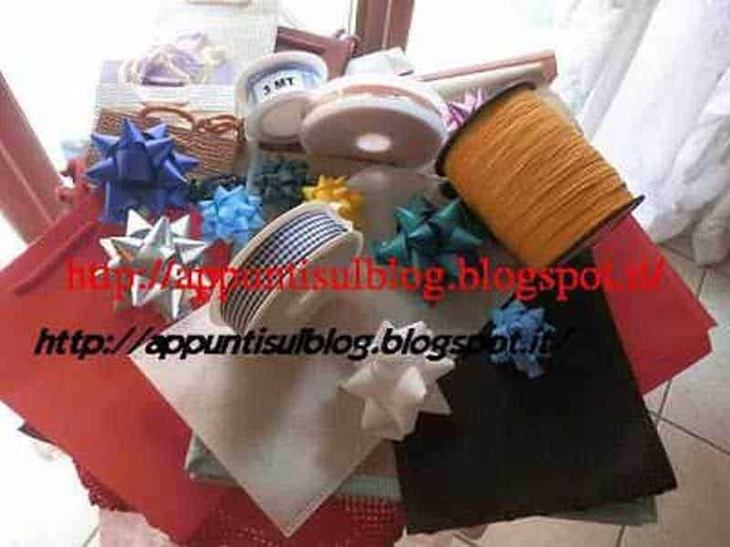 Fiocco regalo blu e argento, nastri colorati, fiocchi e rotoli di rafia, ideali per confezionare regali eleganti e personalizzati. Materiali per decorazioni e confezioni regalo creative e di qualità.