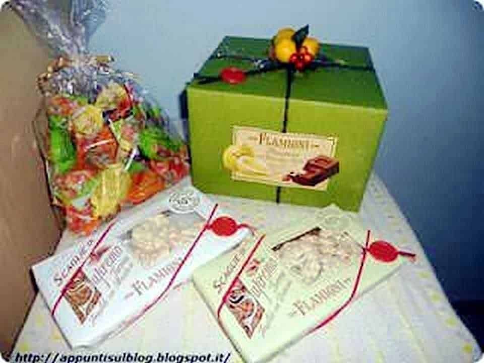 Fiocco regalo con dolci e caramelle, scatola regalo verde decorata con frutta e cioccolato, pacco regalo promozionale di cioccolato e dolci, sacchetti di dolci assortiti, immagini di dolciumi e confezioni regalo per occasioni speciali.