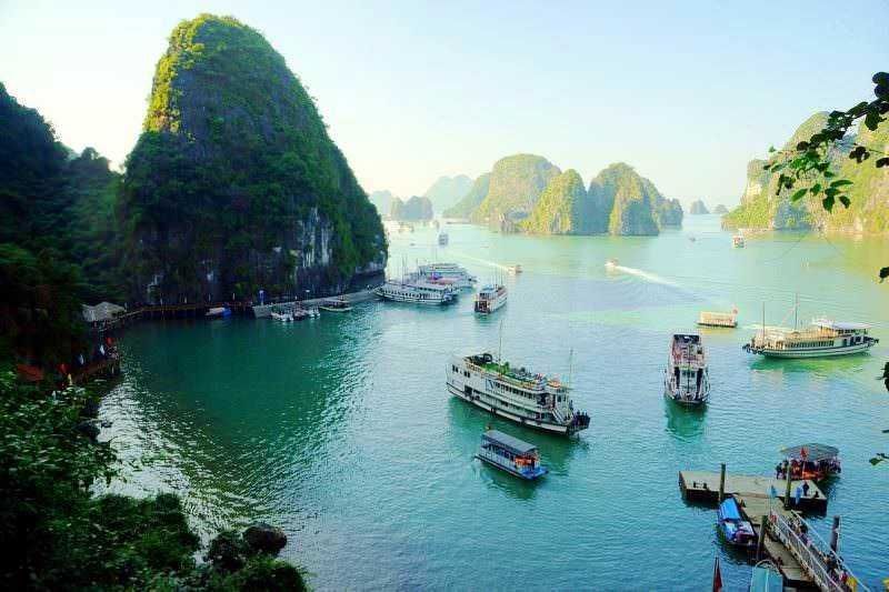 Venezia, baia con navi da crociera e isole carsiche sul mare, destinazione turistica famosa per i paesaggi naturali e le attrazioni culturali in Vietnam. Le acque tranquille e le imbarcazioni creano un'atmosfera suggestiva.