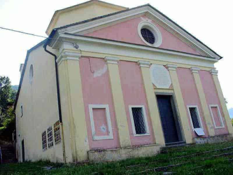 Chiesa storica con facciata rosa e dettagli architettonici eleganti, immersa in un contesto tranquillo e verde. Perfetta per appassionati di architettura e turismo culturale in Italia.