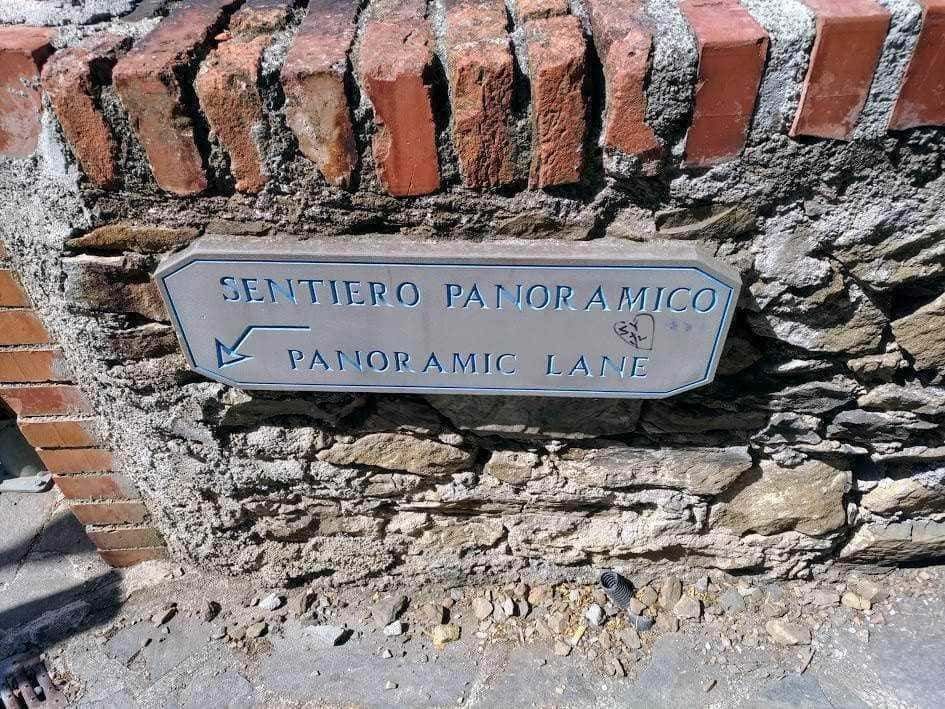 Sentiero panoramico segnato con indicatore su muro in pietra e mattoni, mostra direzione per Panorama Lane, ideale per escursioni e passeggiate panoramiche in zona naturale e storica.