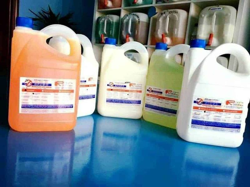 Disinfettante e detergenti per laromac Tec in bottiglie di varie dimensioni su superficie blu in un negozio di pulizie.