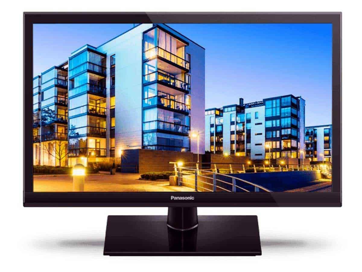 Moderno monitor Panasonic con schermo flatscreen che mostra un complesso residenziale urbano illuminato di sera, ideale per appassionati di tecnologia e design di interni.
