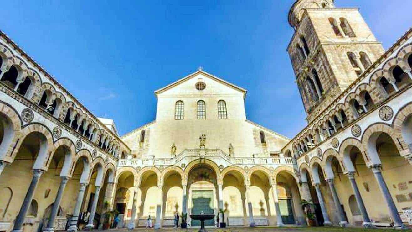 Splendida facciata della basilica di Trento con arco e torre, esempio di architettura storica in Italia.