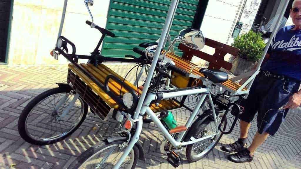 Biciclette tandem con spaziosi sedili in legno e struttura robusta per escursioni all'aperto, ideale per coppie e gruppi che amano pedalare insieme in ambienti urbani o naturali.