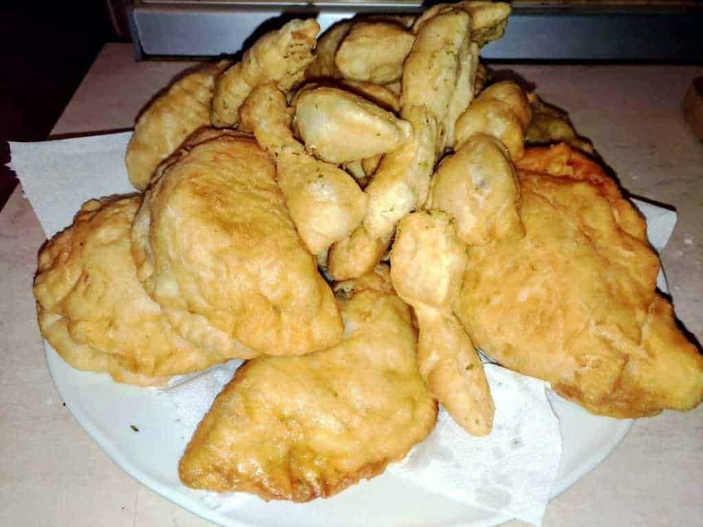 Pollo fritto croccante e dorato con pezzi di pollo fritti e patatine in una teglia, perfetta per una cena gustosa o un pranzo informale.