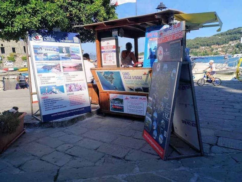 Portovenere: Santuario della Madonna Bianca: cosa vedere e dintorni 14 Barche sul lago con stand promozionali, porticciolo turistico, attività di noleggio barche, offerte di escursioni, servizi per turisti, destinazioni marine.