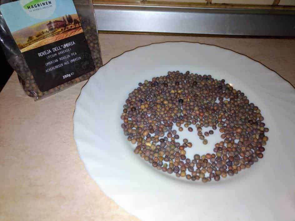 Semi di pepe di Sichuan su piatto bianco, con pacchetto di pepe di Sichuan in sfondo, focusing on aromatic spices e cucina asiatica.