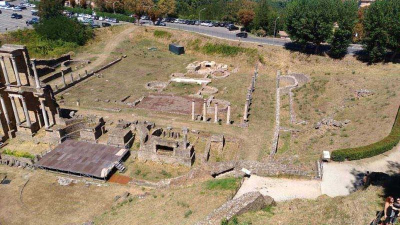 Antica rovina romana e resti archeologici di un sito storico con strutture in pietra e colonne parzialmente conservate, immerso nel verde e visitabile nel parco archeologico.