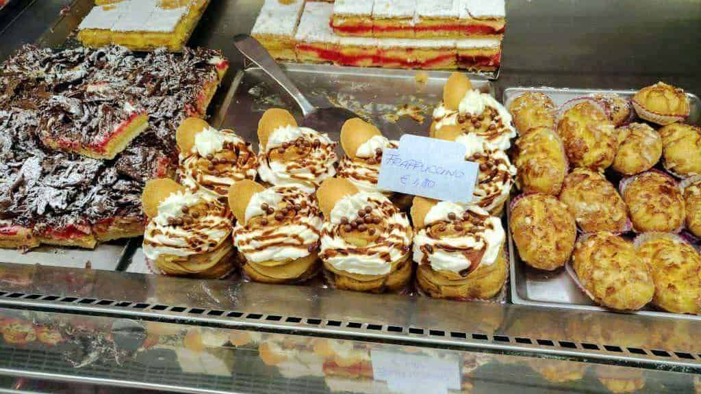 Delizie di pasticceria con crema, cioccolato e biscotti in esposizione. Dolci sfiziosi e golosi, perfetti per ogni occasione di merenda o dessert.