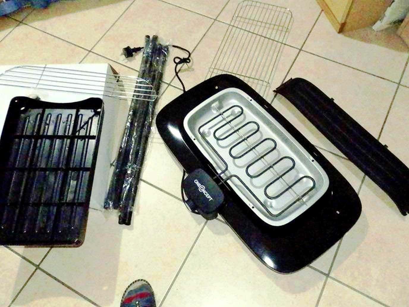 Pannelli radiatori e elementi di riscaldamento elettrico per la casa, smontati e disposti su piastrelle di ceramica, pronti per il montaggio o la sostituzione. Tecnologia e manutenzione degli impianti di riscaldamento.