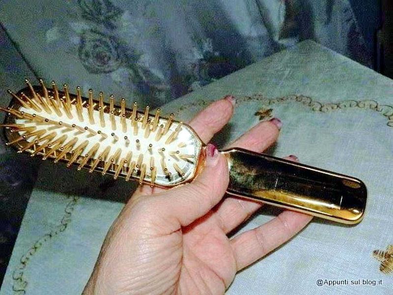 Janeke 1830 accessori moda Vintage 12 Spazzola per capelli dorata con spilli metallici, in mano, su tessuto colorato, accessorio di bellezza elegante, strumenti per capelli di lusso, cura dei capelli, styling femminile, beauty & haircare.