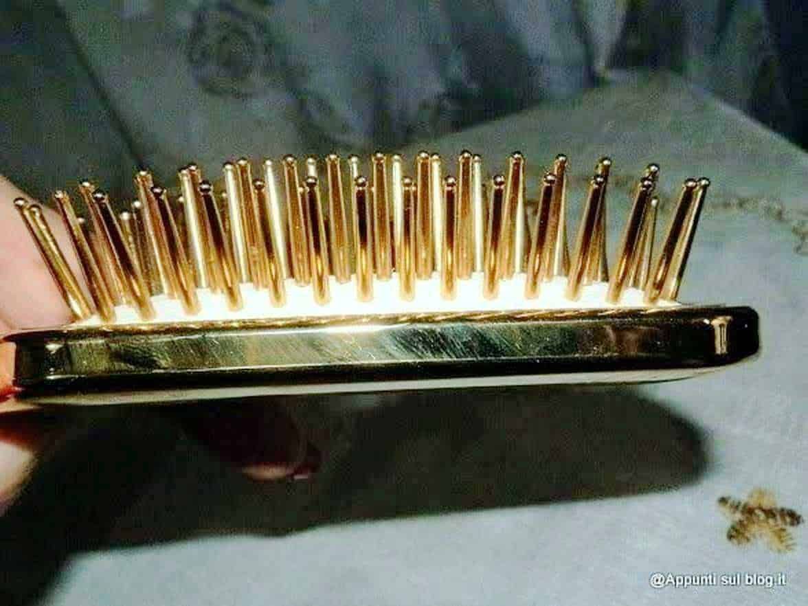 Rastrello per capelli con denti d'oro, oggetto di lusso e accessorio per la cura dei capelli, fotografato in dettaglio su sfondo morbido.