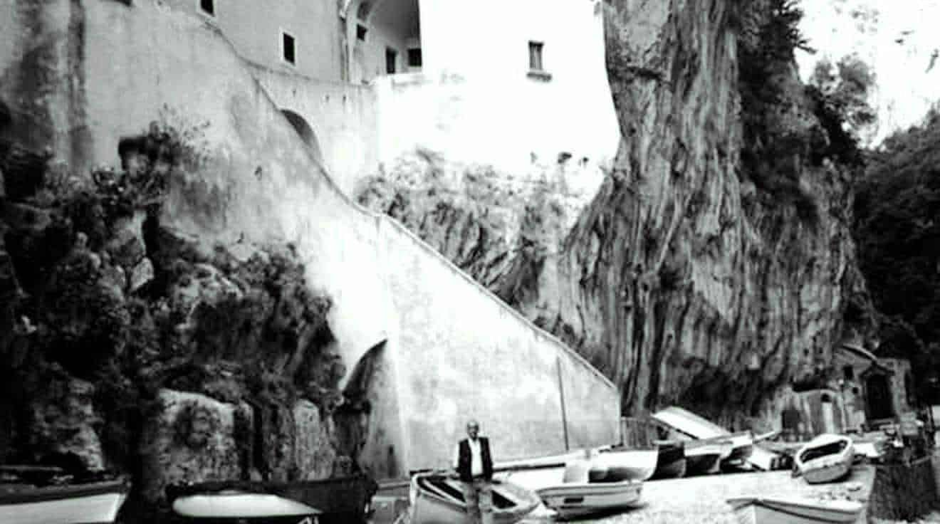 Filemigliorata1.jpg, Immagine di un paesaggio urbano con rocce e case storiche, rappresenta l'arte e l'architettura italiana, ideale per contenuti di blog su viaggi e cultura italiana, con focus su patrimonio storico e architettura.