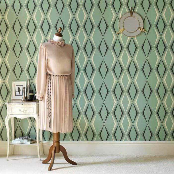 Elegante parete verde con motivo geometrico, vetrina bianca con accessori e manichino con abito in velluto rosa e dettagli vintage. Perfetto per arredamento di interni e styling moda.