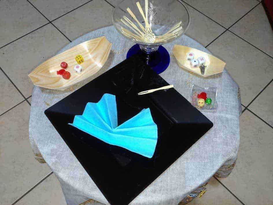 Contenitori monouso per alimenti Papolab. Piatto di plastica nero con design elegante su tavolo rotondo, decorazioni natalizie, e accessori come bicchiere di cristallo e cioccolatini con sprinkles, atmosfera raffinata e in stile festivo.