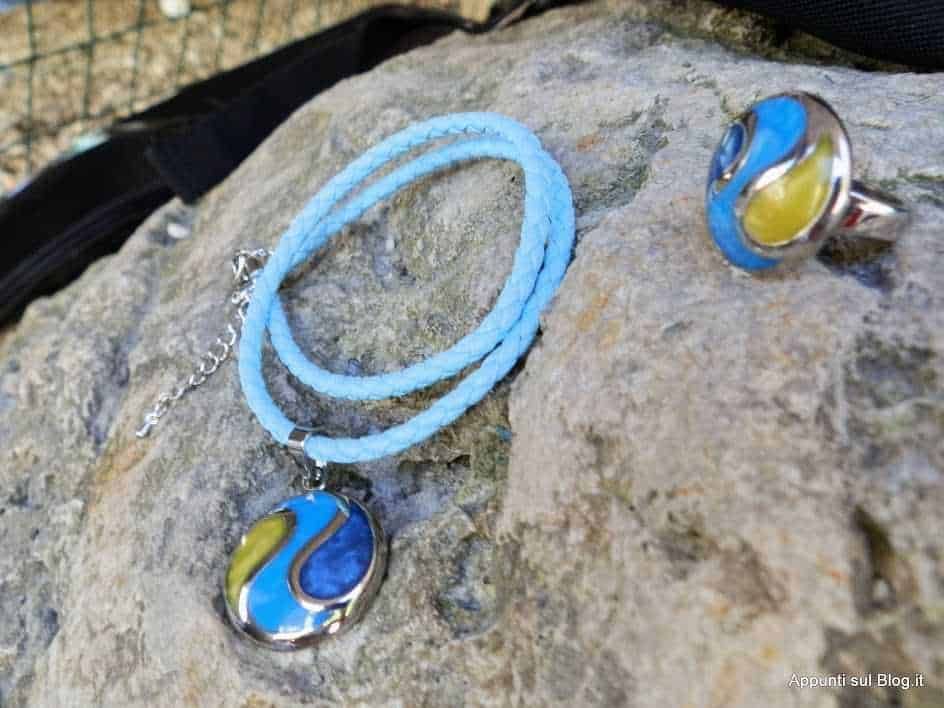 Bracciale e anello in turchese, giallo e blu con dettagli in argento, posizionati su una superficie di pietra, ideali come gioielli estivi e accessori moda, perfetti per uno stile elegante e colorato.